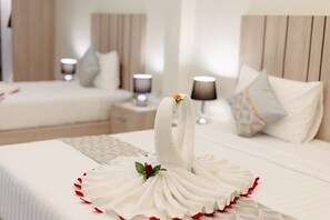 Habitación cuádruple | Ropa de cama de alta calidad, edredón, camas con pillow-top y minibar 