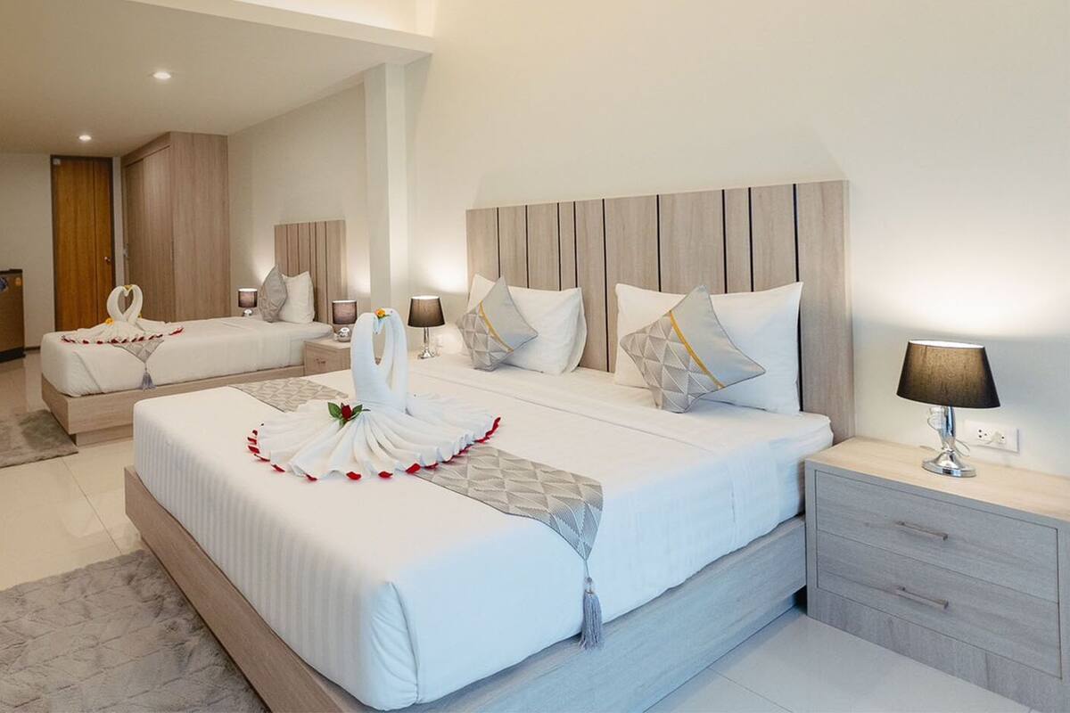 A hotel room with two beds, a desk, and a chair.