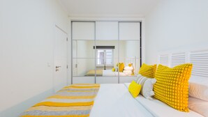 A bedroom with a bed, a mirror, and a sliding door.