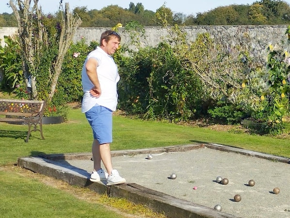 Una persona jugando un juego de pasto con pelotas en un campo cubierto de césped.