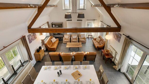 A spacious loft-style living area with high ceilings, exposed wooden beams, and large windows. - Hoeve t` Korenhof - Koksijde (Koksijde)