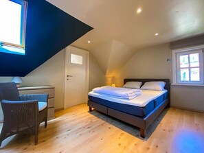 A bedroom with a bed, a chair, a desk, and a window. - Villa Trianon -Summer beachhouse in De Panne (De Panne)