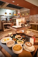 Un bufé de desayuno con diferentes alimentos y una taza de café.