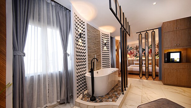 Un baño moderno con una bañera independiente, un espejo grande y un mueble de madera.