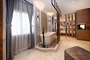 Un baño moderno con una bañera independiente, un espejo grande y un mueble de madera.