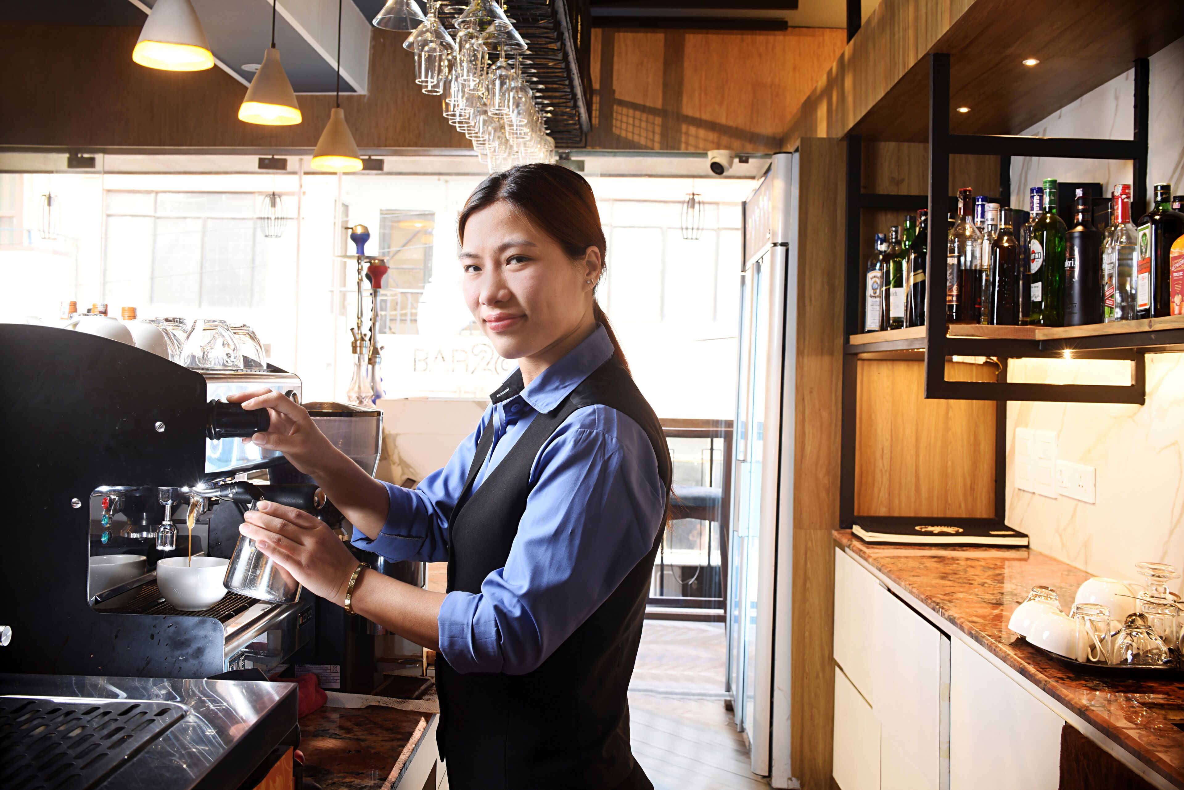 A barista preparing a drink at an espresso machine.