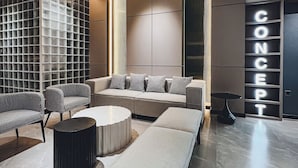 Una sala de estar moderna con un sofá modular, sillas estampadas, una mesa de centro redonda y un diseño minimalista.