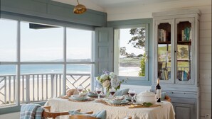 A dining area with a table set for four, overlooking a beach. - Wishome—A Fairytale Home to Extend Summer by the Sea (San Vicente de la Barquera)