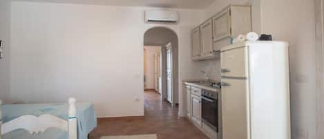 Una cocina compacta con refrigerador, horno y pileta.