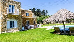 A stone house with a balcony, a pool, and a thatched roof structure. - Hem Borta Villa - Next To Platanias, 2min From Beach (Platanias)