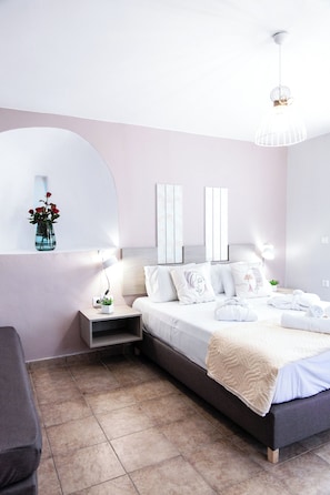 Une chambre à coucher moderne avec un lit, des tables de chevet, un vase de fleurs et un miroir.