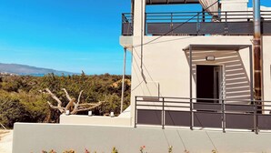A modern building with a balcony, a staircase, and a view of the landscape. - Phaedra House For Relaxing Holidays Near Platanias (Platanias)