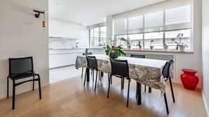 A modern kitchen with a dining area, large windows, and a red vase. - Contemporary Heights, by Veeve (Paris)