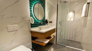 A modern bathroom with a white sink, a mirror, and a shower area. - Q Style Hotel  (Trabzon)
