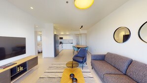 A modern living room with a flat-screen TV, a sofa, a coffee table, and a dining area with a table and chairs. - Savyon V.I.E.W - Luxury 3BR w/ Har HaBayit View (Jerusalem)