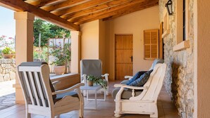 Un patio acogedor con muebles de madera, un muro de piedra y una puerta de madera.