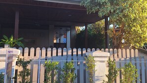 A building with a covered porch and a white picket fence. - Le KhounSok Boutique Hotel (Luang Prabang)