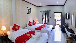 A hotel room with two beds, a desk, a mirror, and a view of the outdoors. - Le KhounSok Boutique Hotel (Luang Prabang)
