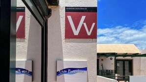Entrada de hotel con un cartel que dice 'Casa Barcelona' y otro cartel que indica 'Viviendas Vacacionales'.