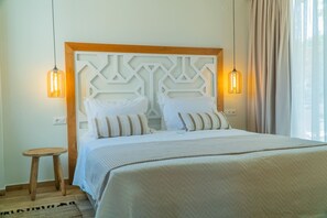 A neatly made bed with a wooden headboard and two bedside lamps. - Vita Brevis - Premium Villa 1,5km From The Beach (Rethymno)