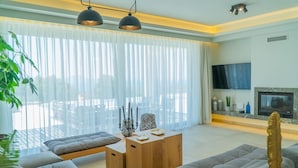 A modern living room with a sofa set, a wooden coffee table, and a TV mounted on the wall.