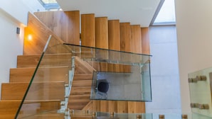 A modern staircase with glass railings and wooden steps.