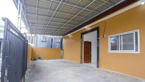 A spacious indoor area with a concrete floor, a metal roof, and a yellow wall. - OYO 92626 Good Sleep 4 Inn Dcos Syariah (Samarinda)