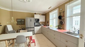 Une cuisine moderne avec un coin repas, de grandes fenêtres et une vue sur la ville.