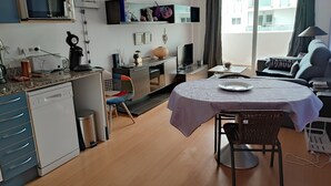 Moderni keittiö, jossa on astianpesukone, mikroaaltouuni sekä ruokailutila pöytineen ja tuoleineen.
