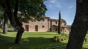 A stone building with a tiled roof, surrounded by a well-maintained lawn and trees. - Villa in Foiano Della Chiana with 6 bedrooms sleeps 14 (Foiano Della Chiana)
