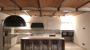 A modern kitchen with a central island, bar stools, and a hanging light fixture. - Villa in Foiano Della Chiana with 6 bedrooms sleeps 14 (Foiano Della Chiana)