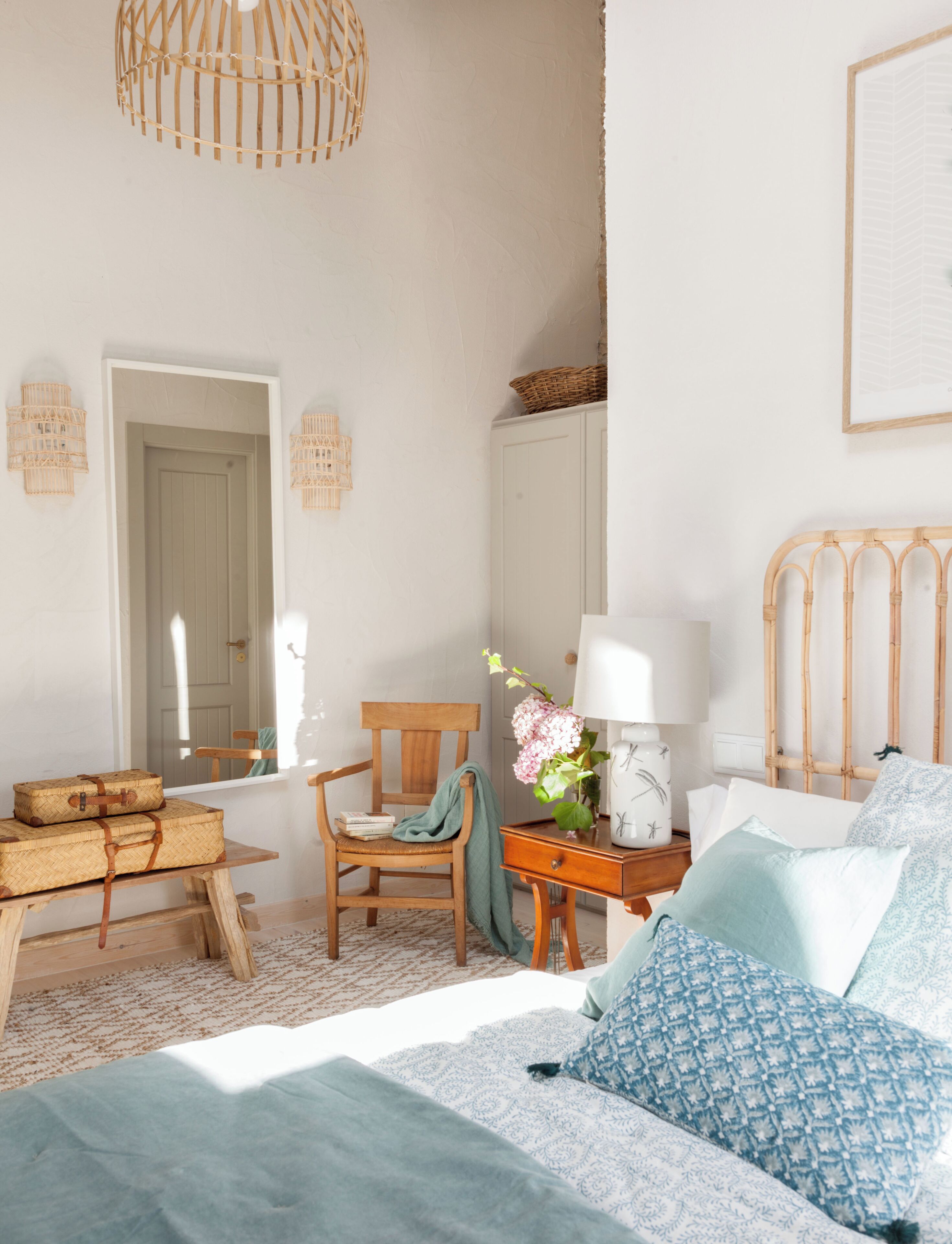 Un dormitorio con cama, una silla, una mesa y un armario.
