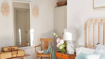 Un dormitorio con cama, una silla, una mesa y un armario.