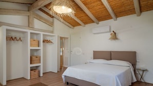 A bedroom with a bed, a wardrobe, and a small table. - Villa Canto Antico -SARDINIA UNLIMITED (Porto San Paolo)