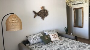 A bedroom with a bed, a wall-mounted fish decoration, a hanging light fixture, and a mirror. - Magnifique VUE MER Golfe DE ST Tropez (La Croix-Valmer)