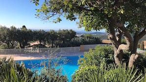 A pool surrounded by lush greenery and trees, with a view of distant hills and a clear sky. - Magnifique VUE MER Golfe DE ST Tropez (La Croix-Valmer)
