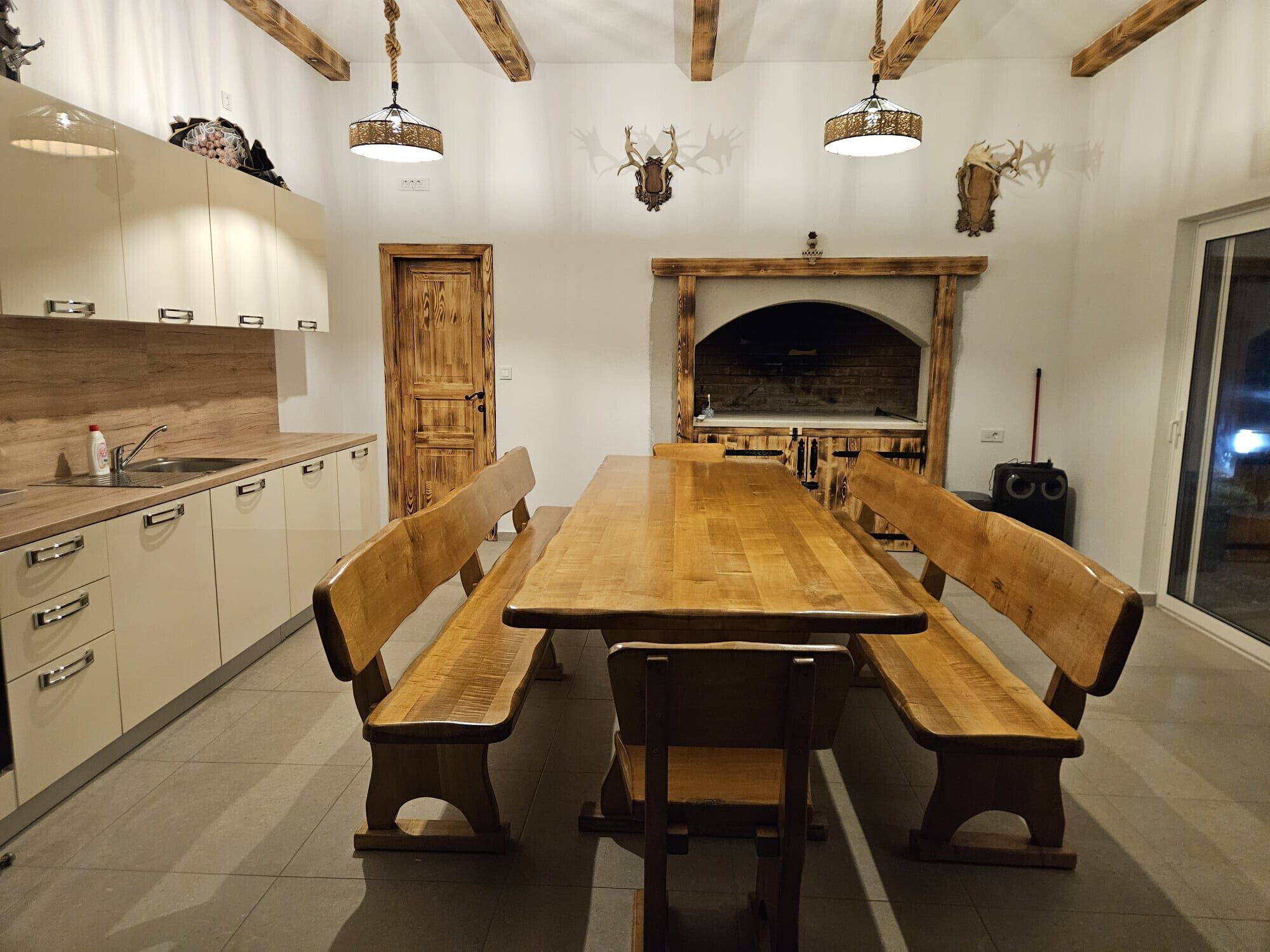 A kitchen with wooden benches, a fireplace, and a dining table.