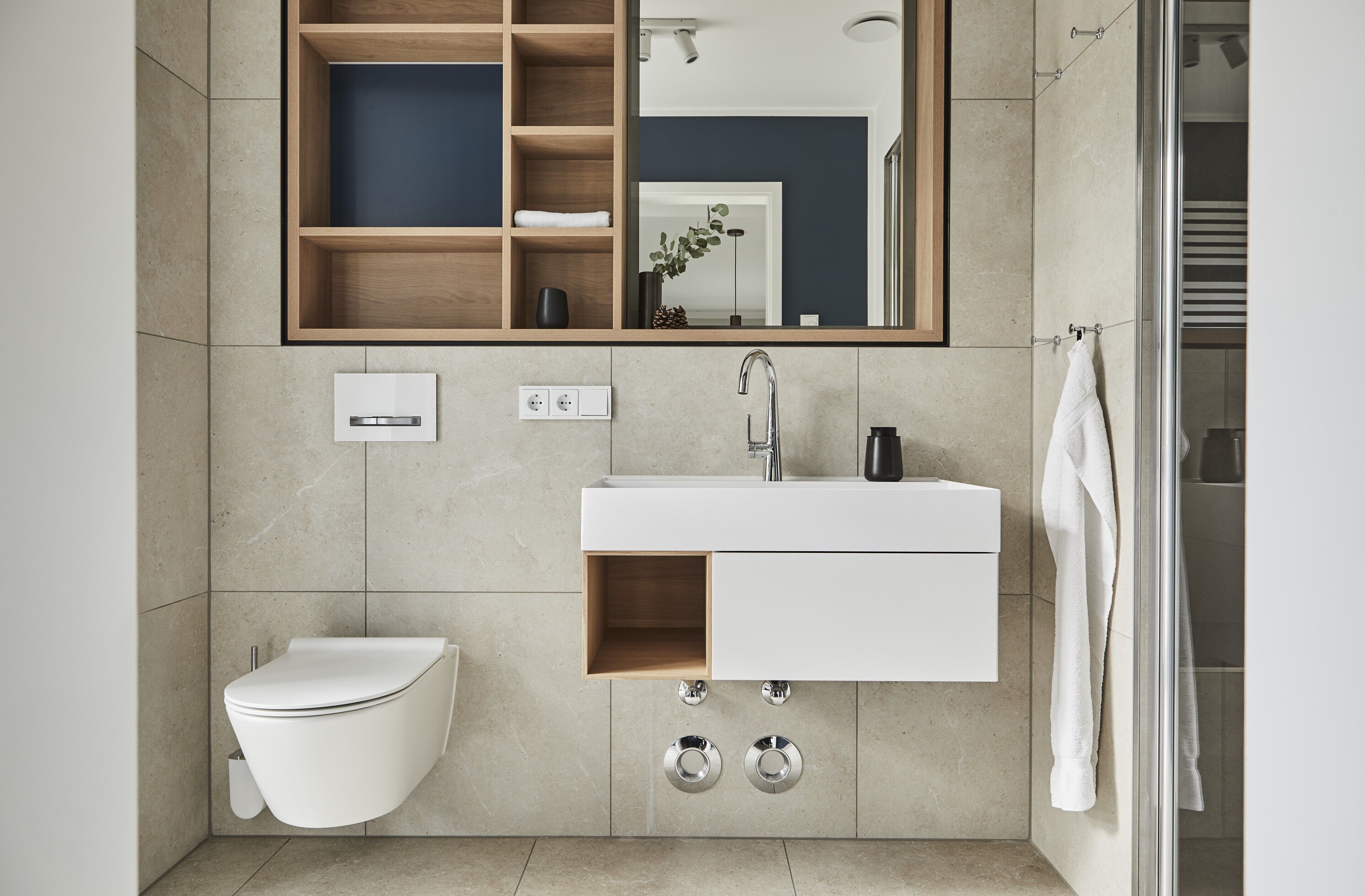 Ein modernes Badezimmer mit Toilette, Waschbecken und Spiegel.