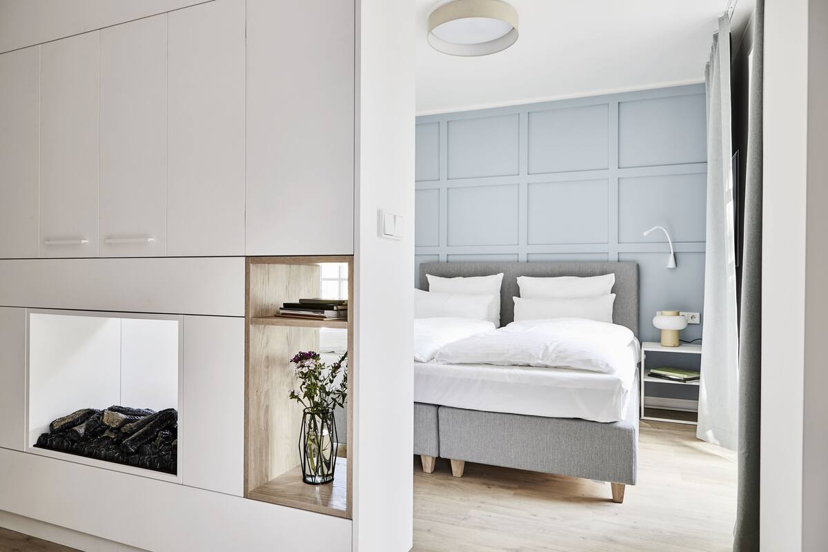 Un dormitorio moderno con cama, mesita de noche y armario empotrado.