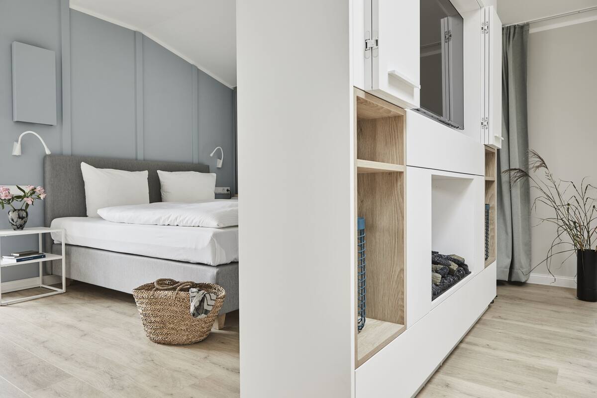 Un dormitorio moderno con cama, mesita de noche y un armario grande.