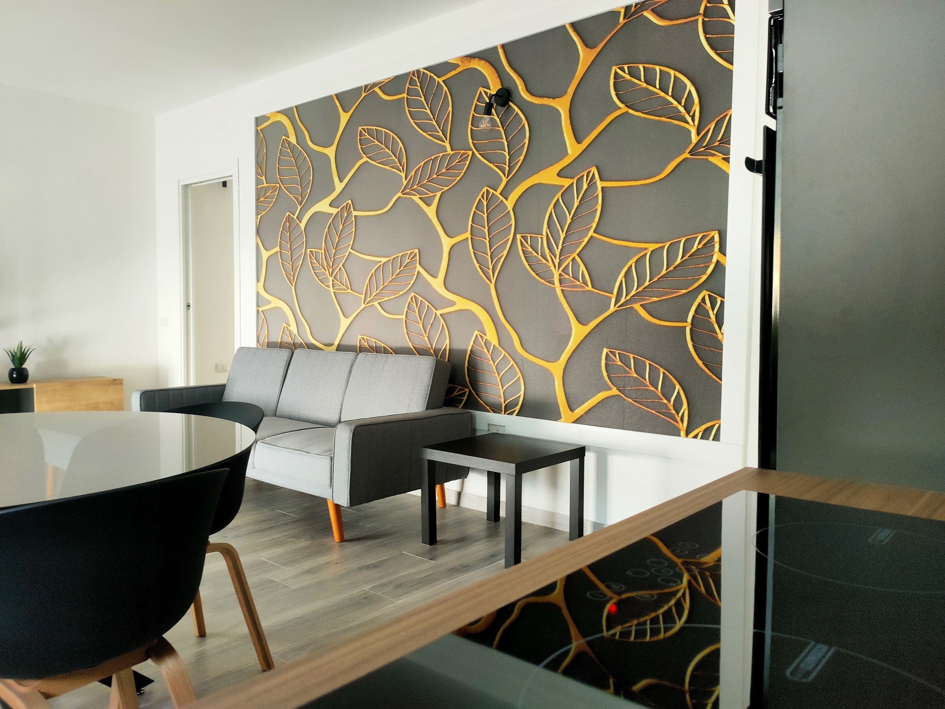 Un salon moderne avec un canapé, une table basse et une cloison en verre.