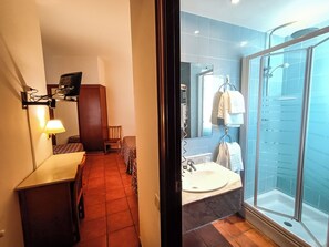 A hotel bathroom with a glass-enclosed shower, a sink, and a mirror. - Hotel Can Solé (Cambrils)