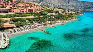 A coastal town with a marina, beachfront seating, and terraced buildings. - Leyla Luxury Villa with Spinalonga View (Vrouchas)