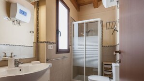 A bathroom with a sink, toilet, and shower area. - Luna d'Argento by Wonderful Italy - Kimama (Siracusa)