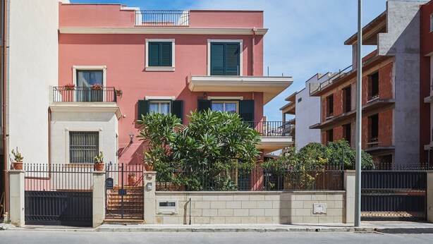 A residential building with a balcony, a gated entrance, and a street lamp. - Nice Studio on the Terrace (Pozzallo)