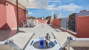 A rooftop terrace with a table set for two, a cocktail shaker, and a glass. - Nice Studio on the Terrace (Pozzallo)