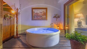 A spa area with a large bathtub, wooden flooring, a wall-mounted painting, and a window with a view of the outside. - Gapyeong Labelle Pension (Gapyeong)