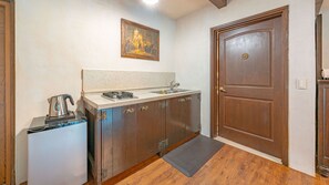 A compact kitchen with a sink, stove, and a kettle. - Gapyeong Labelle Pension (Gapyeong)