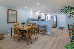 A modern kitchen with white cabinets, a central island, and stainless steel appliances.