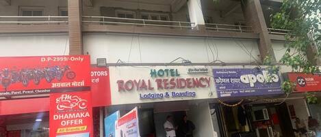 A hotel named Royal Residency with a signboard advertising a Dhamaika offer.